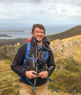 Neil with mountains and water in background