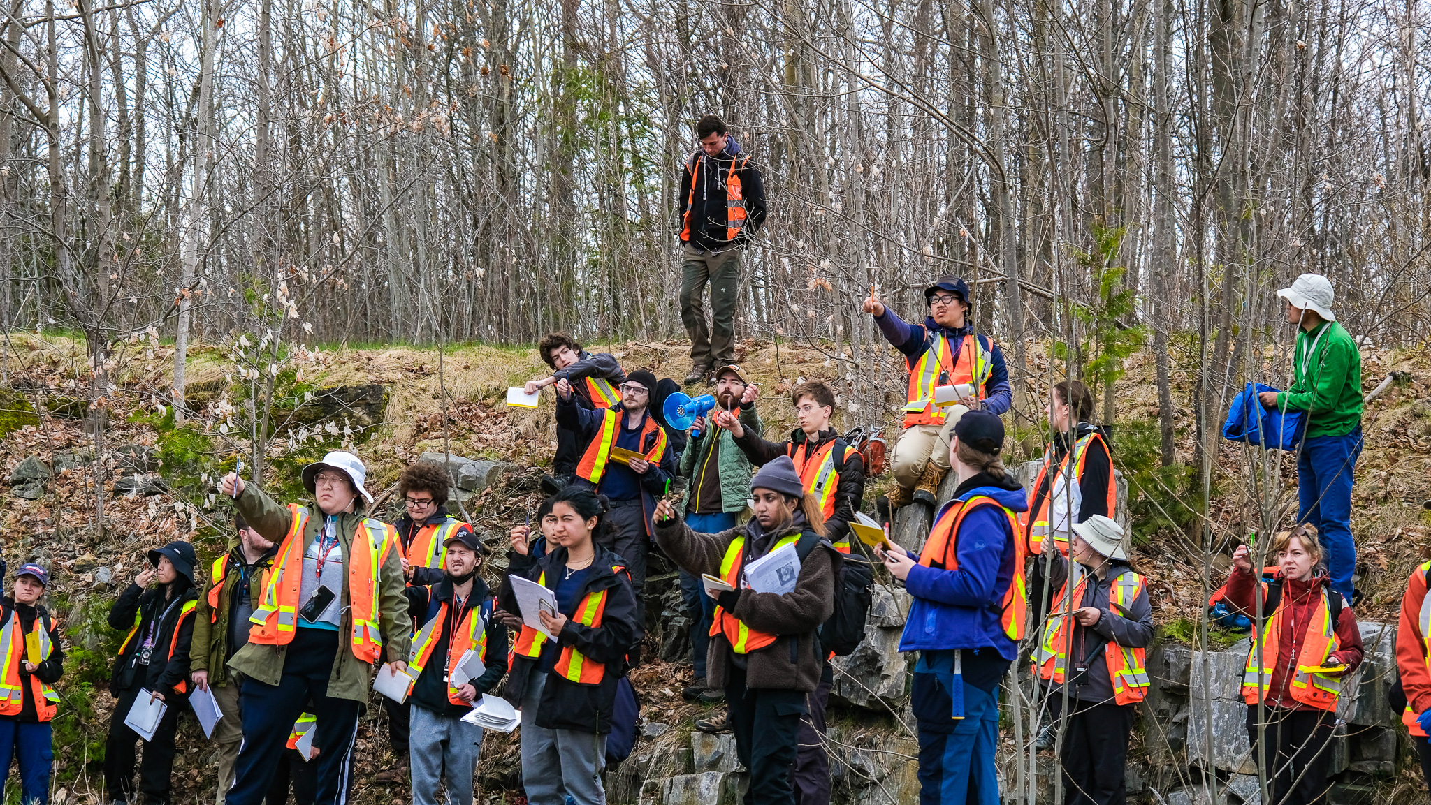 students using their pens to estimate measurements of an outcrop