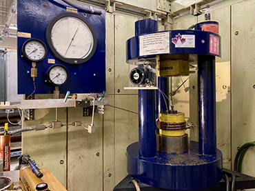 a blue piston cylinder press in a laborartory