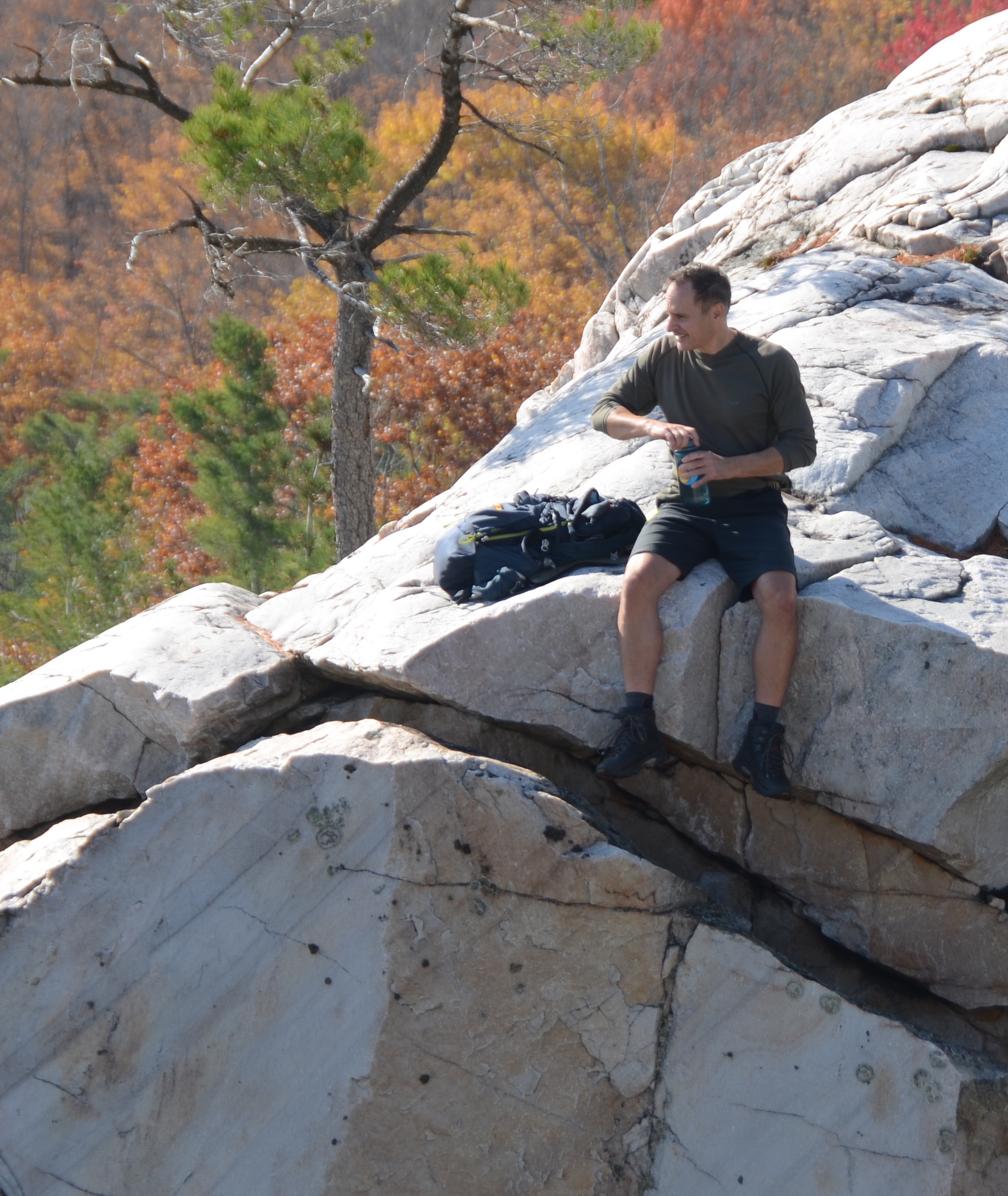 Russ on white rock cliff with fall colours in the background