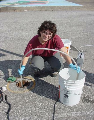 a scientist collecting groundwater in a bucket