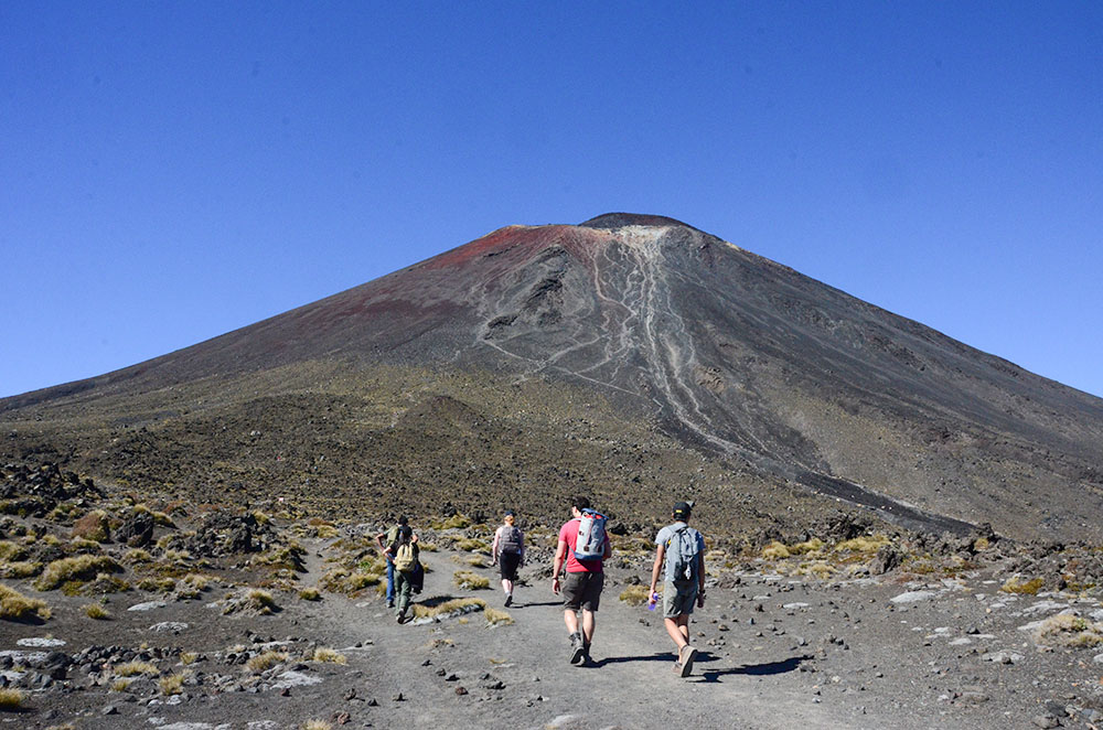 four students walking towards a dormant volcano in New Zealand