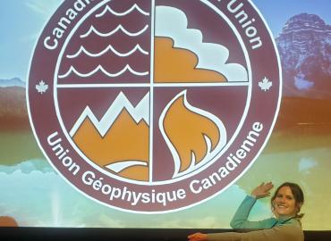 Julia Andersen poses beside the Canadian Geophysical Union (CGU) logo during the CGU&amp;#039;s Annual Scientific Meeting