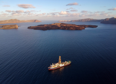 a research ship viewed from above with islands in the distance