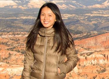 Corliss standing red-orange geologic landscape in background