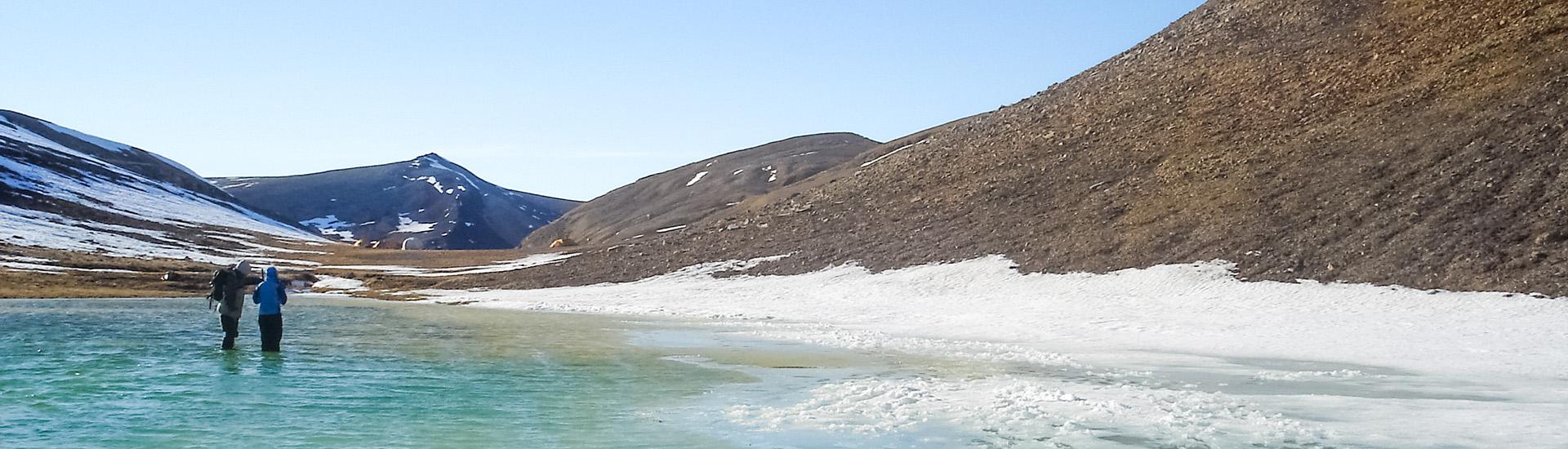 two people taking samples in an artic lake